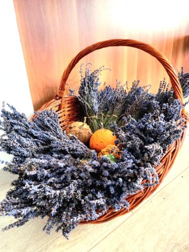a basket filled with purple flowers and fruit on a table at Casa David in Dunăvăţul-de-Sus