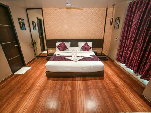 a bedroom with a large bed with red pillows at WoodApple Residency in New Delhi