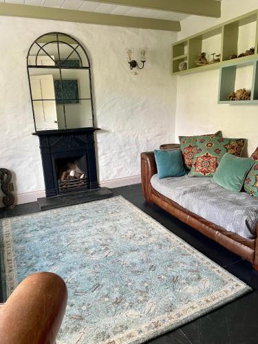 a living room with a couch and a fireplace at Sea Haze Charlestown in St Austell