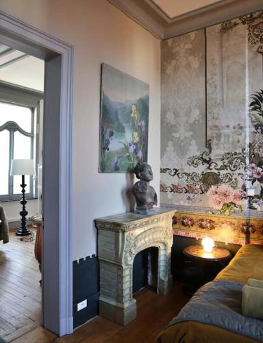 un salon avec une cheminée et un tableau au mur dans l'établissement Maison Verte, Monument Historique, à Roubaix