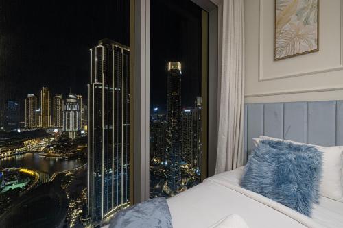 a bedroom with a view of a city at night at Luxury 4BR Burj Khalifa & Fountain Views in Dubai