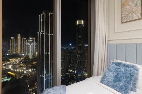 a room with a view of a city at night at Luxury 4BR Burj Khalifa & Fountain Views in Dubai