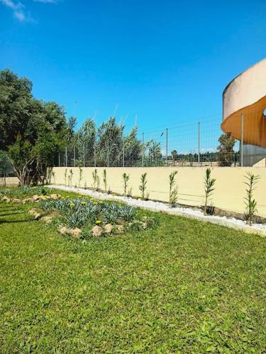 a fence with plants in a field next to a building at Calma House in Kanálion