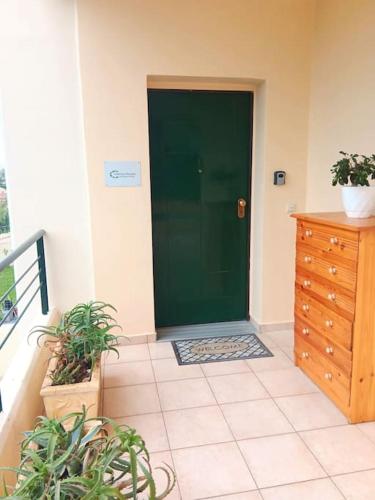 a green door in a room with potted plants at Calma House in Kanálion