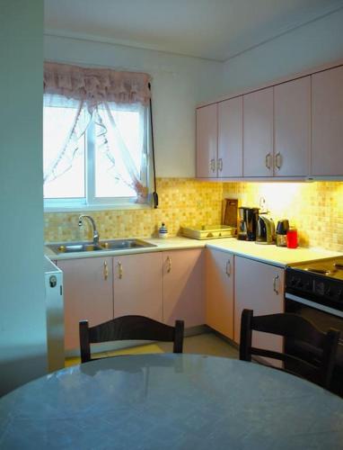 a kitchen with a table and a sink and a window at Calma House in Kanálion