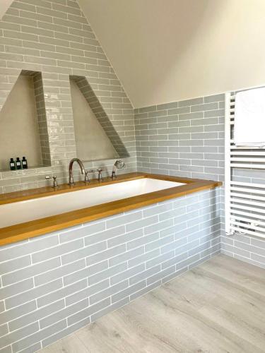 La salle de bains est pourvue d'une grande baignoire et d'un lavabo. dans l'établissement Villa vue mer panoramique en Baie de somme, à Ault