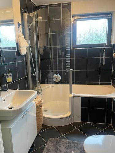 a bathroom with a tub and a sink and a shower at Ferienhaus Mathilda in Kusel