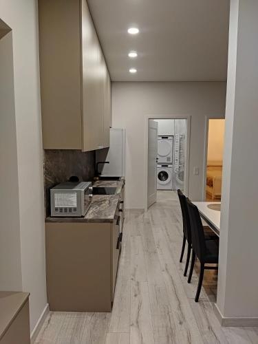 a kitchen with a counter and some chairs in a room at Aušros Alėjos Apartamentai in Šiauliai