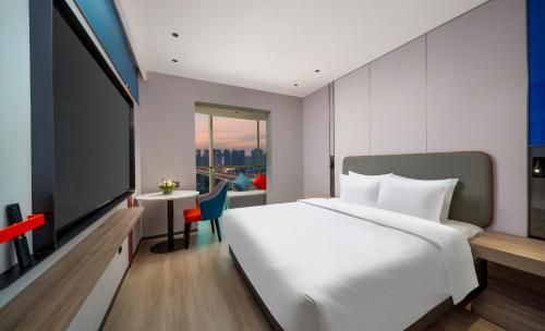 a bedroom with a large bed and a flat screen tv at Holiday Inn Express Zhengzhou Garden Road in Zhengzhou