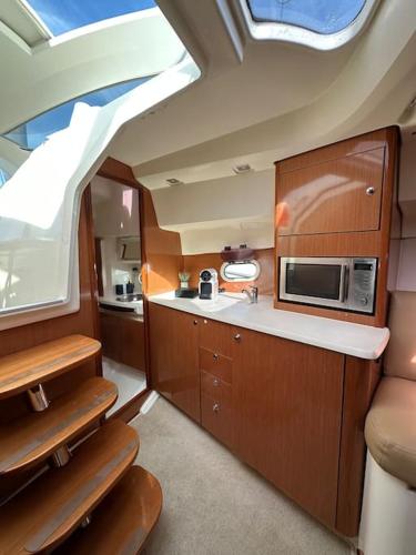 une petite cuisine avec un évier et un micro-ondes dans l'établissement Nuit, à quai, à La Rochelle