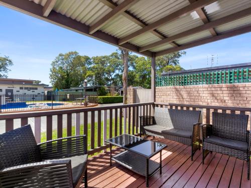 a patio with chairs and a table on a deck at Shoalhaven Heads Village in Shoalhaven Heads