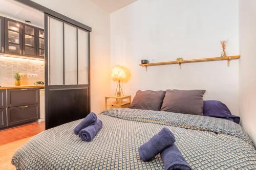 - une chambre avec un lit et des serviettes pourpres dans l'établissement La jolie escale du Panier Mucem Vieux Port, à Marseille