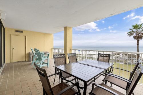 a dining table and chairs on a balcony with the ocean at Summer House Condos in Orange Beach