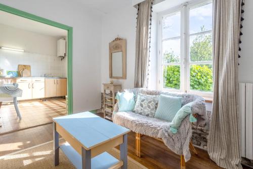 un salon avec un canapé et une table dans l'établissement Petite maison plage 5min en voiture, à Plobannalec-Lesconil