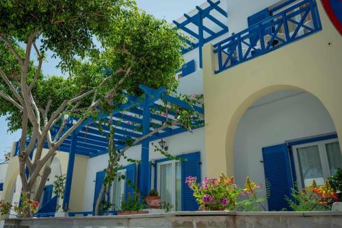 a blue and white building with blue shutters at Karidis Hotel in Kamari