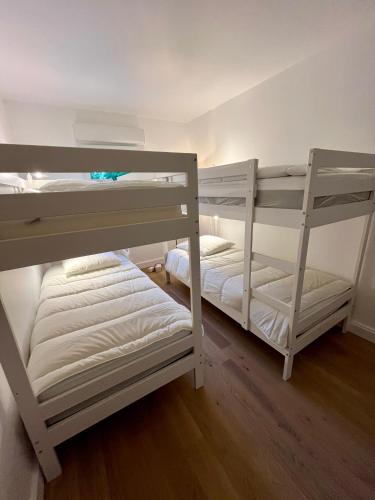Ce lit se trouve dans un dortoir doté de 2 lits superposés et de murs blancs. dans l'établissement Villa Cano 8 personnes à 250m de l'océan, à Lacanau-Océan