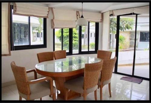 a dining room with a glass table and chairs at Navaphirom Resort Cha am in Cha Am