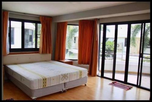 a bedroom with a bed and large windows at Navaphirom Resort Cha am in Cha Am
