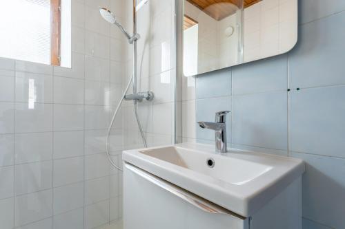 a white bathroom with a sink and a shower at Hortensias - plage 5min en voiture in Plobannalec-Lesconil