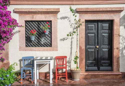 two chairs and a table in front of a door at Siyah Lale Cunda 1841 in Cunda