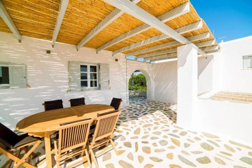 a dining room with a wooden table and chairs at Coral Villa with 4 bedrooms in Paros in Santa Maria