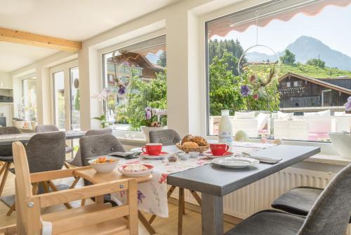 a dining room with a table and chairs and a large window at bichl 761 in Fischen