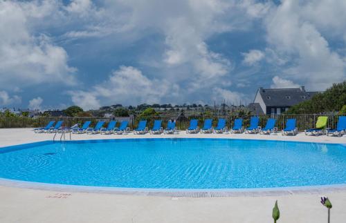 une grande piscine avec des chaises et des chaises de jardin dans l'établissement Face à la marina belle maison pour 6, à Arzon