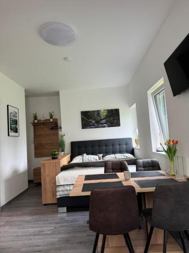 a bedroom with a bed and a table and chairs at Apartmány Rak Lipno in Černá v Pošumaví