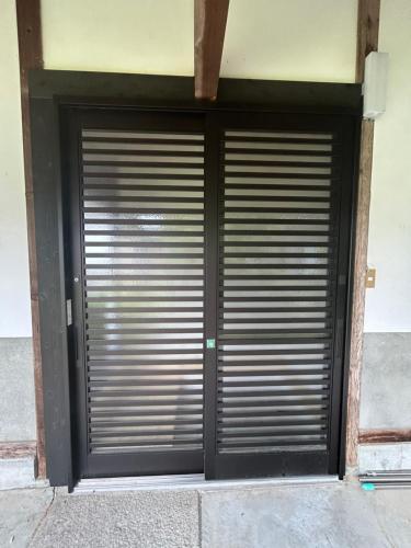 a large metal garage door on a building at 高島市一棟貸切 Biwa Lake琵琶湖 徒歩0分 大人数でご利用だとお得連泊がお得BBQ自転車無料利用可ペット可 in Takashima