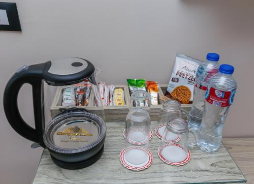 a table with a coffee maker and bottles of water at Horizon Pyramids View inn in Cairo