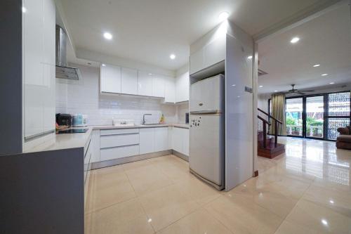 a kitchen with white cabinets and a stainless steel refrigerator at Pool Villa at Central Pattaya Near Big C-EXTRA in Pattaya