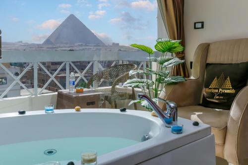 a bathroom with a tub and a view of the pyramids at Horizon Pyramids View inn in Cairo