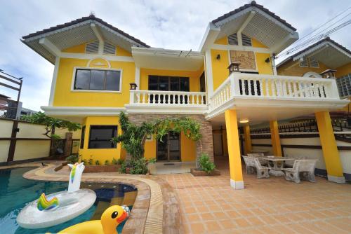 a yellow house with a swimming pool in front of it at Pool Villa at Central Pattaya Near Big C-EXTRA in Pattaya