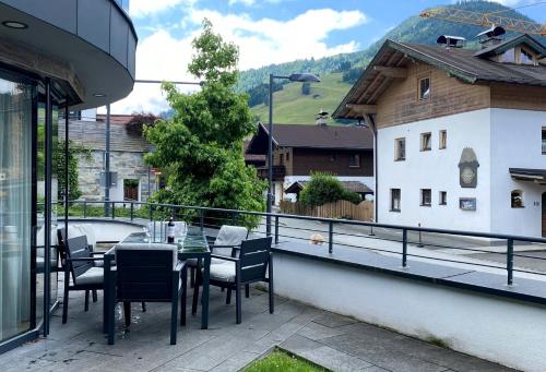 a patio with a table and chairs on a balcony at Mountain Chalet Kirchberg by Apartment Managers in Kirchberg in Tirol
