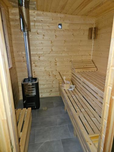 a wooden sauna with a wood stove in it at Domek Pod Cisem na wyłączność in Kierzkowo