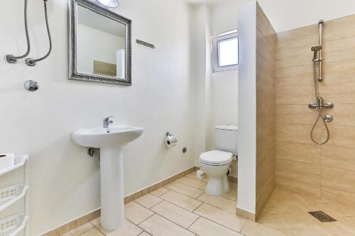 a bathroom with a sink and a toilet and a mirror at Apartmani BLUE MOON in Dobra Voda
