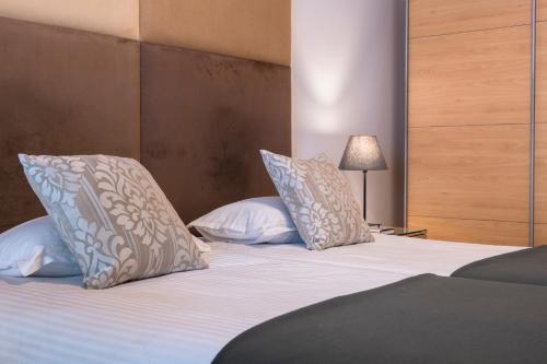 a bedroom with a bed with two pillows on it at Plaza Regency Hotels in Sliema