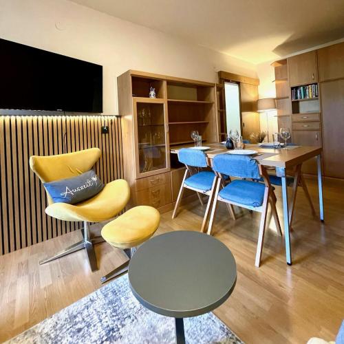 a kitchen with blue and yellow chairs and a table at Casa Alpina Top 33 in Saalbach Hinterglemm