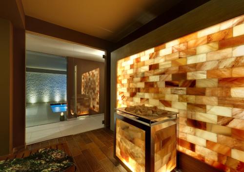 Chalet du Lys Hotel & SPA في غريسّوني لا ترينيتي: غرفة بجدار حجري مع موقد