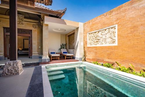 a swimming pool in the backyard of a house at Svarga Bebek Villas in Ubud