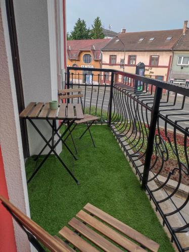 a balcony with a table and bench on a balcony at Stafétaház Apartmanok in Vác