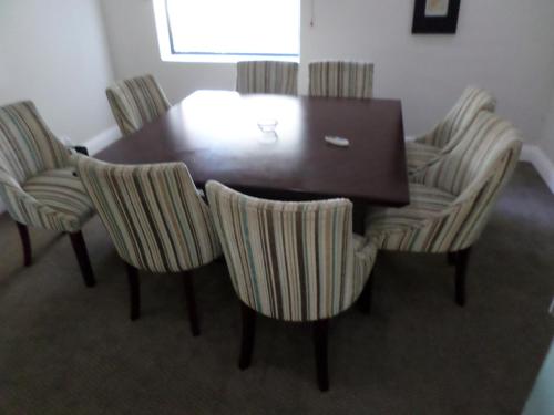 a dining room table with four chairs and a wooden table at Isango Gate in Port Elizabeth