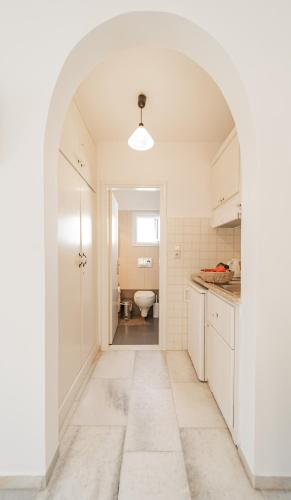 an archway in a white kitchen with a toilet at Agia Anna Living in Agia Anna Naxos