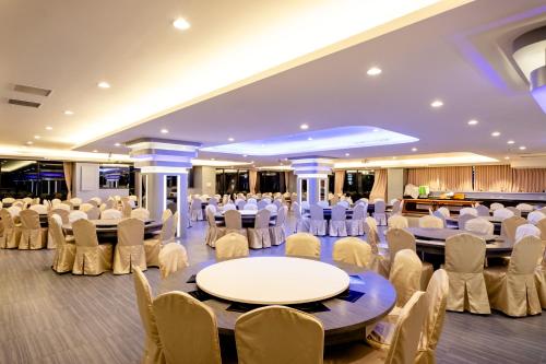 a banquet hall with tables and chairs in a room at Chii Lih Resort in Luye