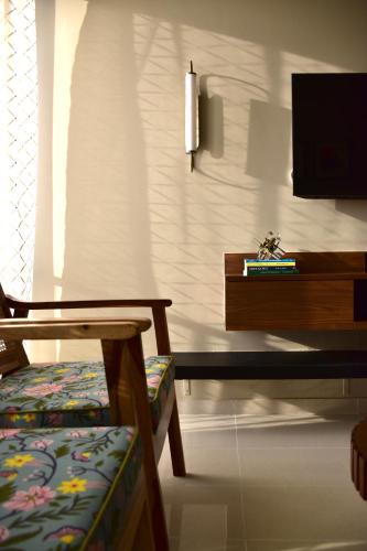 a living room with a chair and a tv at Elegant 2BHK at Tata Rio De Goa in Vasco Da Gama
