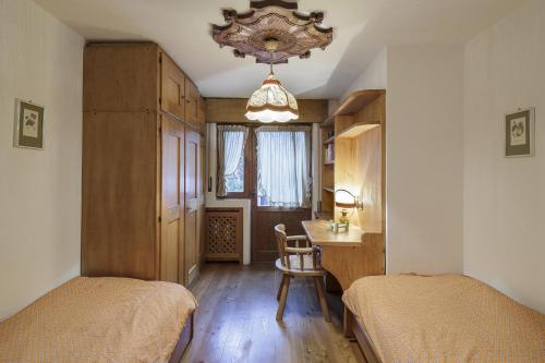 een slaapkamer met 2 bedden, een bureau en een tafel bij Villa Riadezeto - Stayincortina in Cortina dʼAmpezzo