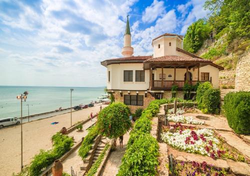 a building on the beach next to the ocean at Villa Komitata-Pool and Jacuzzi in Balchik