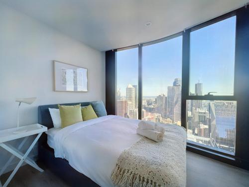 a bedroom with a large bed with a large window at Beautiful 4B3B CBD Melbourne apartment Free WIFI in Melbourne