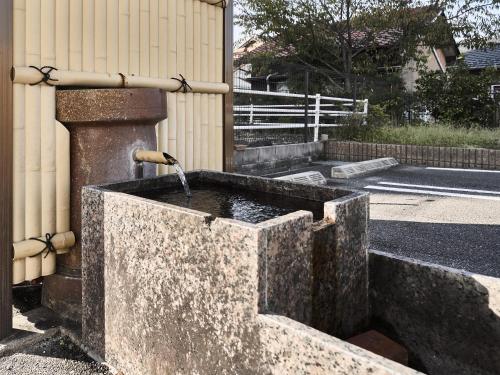 a stone water fountain in a street next to a building at Okasan Hotel in Ogaki