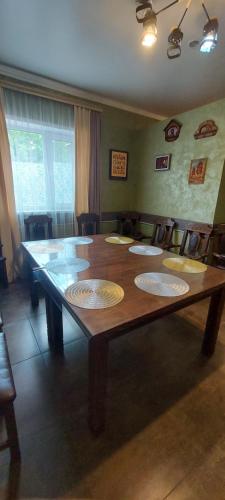 a large wooden table with five plates on it at Гостевой дом 777 in Shchūchīnsk